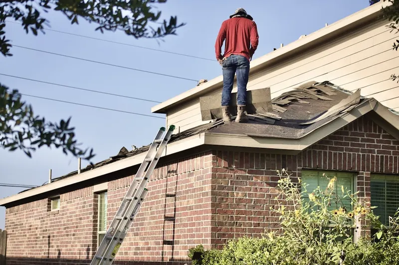 Professional roofer working on a residential roof in Holmen